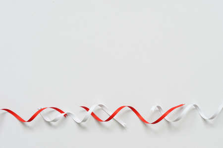 Christmas background concept with red and white paper ribbon swirl placed on blank clean white paper with soft shadow,の写真素材