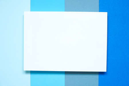 top view of blank clean white mock up card on variety of blue paper shades , copy space, flat lay..の写真素材