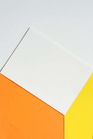 vertical image of blank clean white brochure on orange and yellow paper against white paper...
