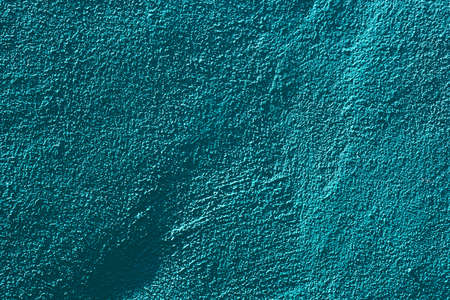 rough surface of green concrete wall with hard shadows for background.