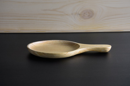 Blank wood plate on black table and wood backgroundの写真素材