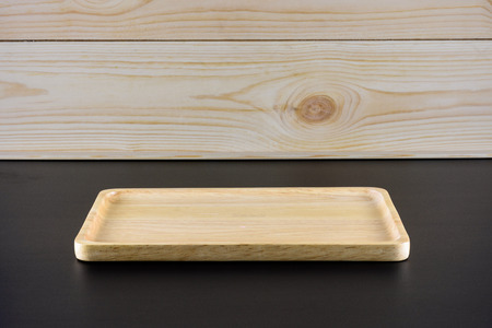 Blank wood plate on black table and wood background