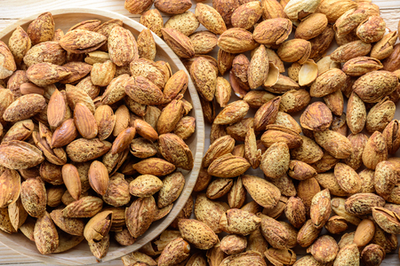 Almond nuts in shell baked with butter and salt on woodenの写真素材