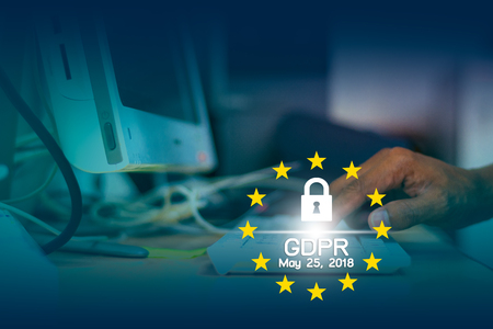 General Data Protection Regulation (GDPR) and May 25, 2018 text with key locker and yellow stars with hand pressing keyboard on backgroundの写真素材