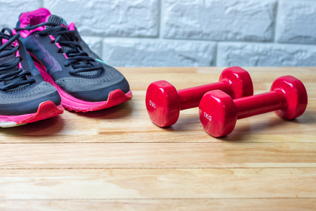 Dumbbells and sport shoes on wooden floor, fitness conceptの写真素材