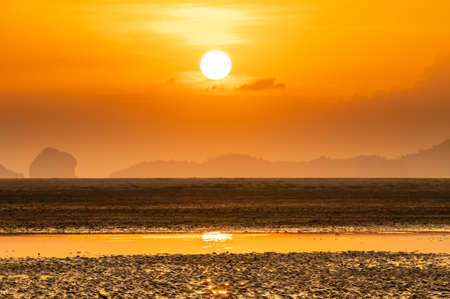 Landscape of beach over orange sunshineの写真素材