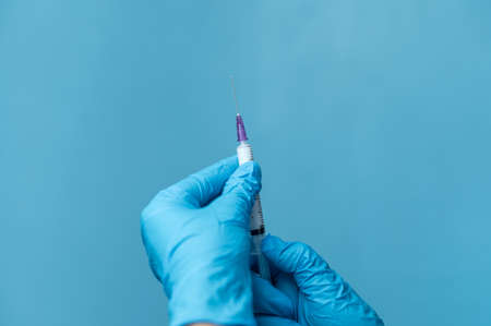 Hands with gloves holding syringeの写真素材