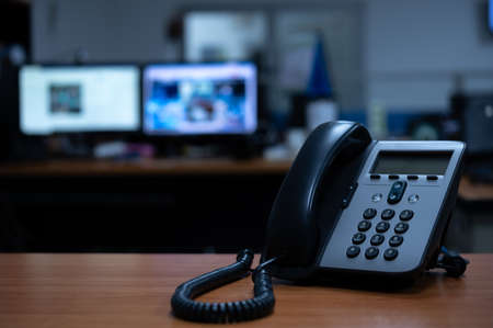 IP telephone device on wooden table in office roomの写真素材