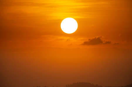 Sun on orange sky with cloudの写真素材