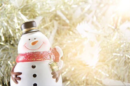 Merry Christmas or Happy New Year background concept : Cute snowman on gold streamer or tinsel backgroundの写真素材