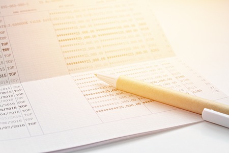 Business, finance, savings or mortgage background concept ; Pen and savings account passbook on white backgroundの写真素材