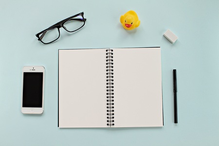 CHONBURI, THAILAND - December 5, 2016 : Workspace desk with blank notebook, Iphone5, glasses and office stationery set on blue background for business or work dayのeditorial素材