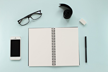 CHONBURI, THAILAND - December 5, 2016 : Workspace desk with blank notebook, Iphone5, glasses and office stationery set on blue background for business or work dayのeditorial素材