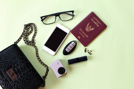 Fashion or travel concept : Top view of black woman bag with lipstick, earrings, small action...