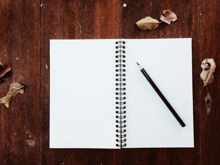 Blank notebook and pencil on wooden tableの写真素材