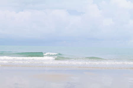Nature background concept : Sand beach and clear transparent sea wave with foam and blue sky