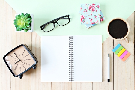 Still life, business, planning or education concept : Office desk table with open notebook paper, accessories and coffee cup, Top view or flat lay with copy space ready for adding or mock upの写真素材