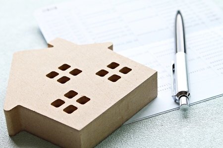 Business, finance, savings, property ladder or mortgage loan concept : Wood house model and pen on saving account passbook  or financial statementの写真素材