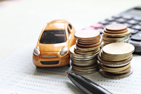 Business, finance, saving money, banking or car loan concept : Miniature car model, coins stack, calculator and saving account book or financial statement on office desk tableの写真素材