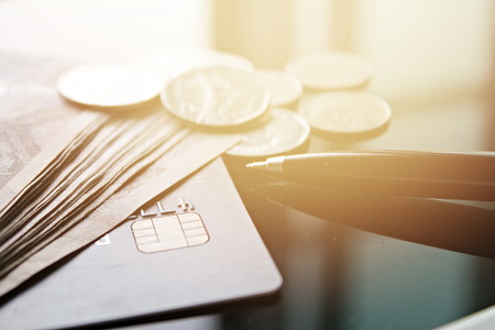 Business, finance, credit card, shopping, saving money, banking, loan, investment, taxes or accounting concept : Credit card, money, coins and pen on office desk tableの写真素材