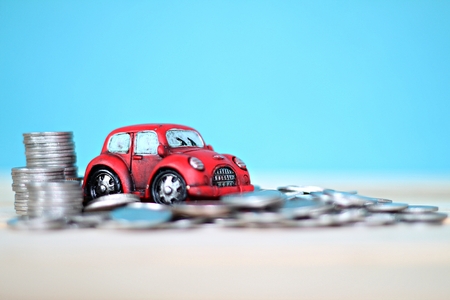 Business, finance, saving money or car loan concept : Miniature car model and coins stack on desk tableの写真素材