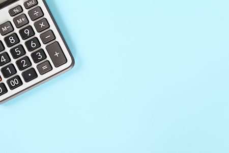 Business, finance, savings money, investment, taxes or accounting concept : Calculator on blue background with copy space ready for adding or mock upの写真素材