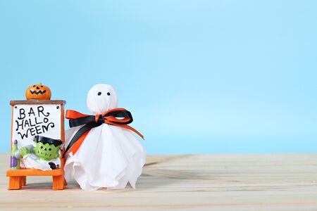 Halloween holiday background concept : Halloween decoration with ghost on table and blue background with copy space, ready for adding or mock upの写真素材