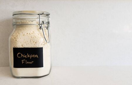 Chickpea flour in a bail-lid style jar against a spotted quartz countertopの写真素材