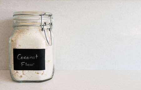 Coconut flour in a bail-lid style jar against a spotted quartz countertopの写真素材