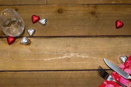 Valentine's Day Background with heart shaped chocolates and silverware on wooden textureの写真素材
