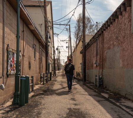 Man walking down an isolated alleyの写真素材