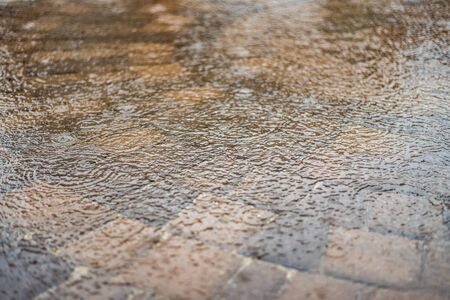 heavy rain on water that is flooding patio paversの写真素材