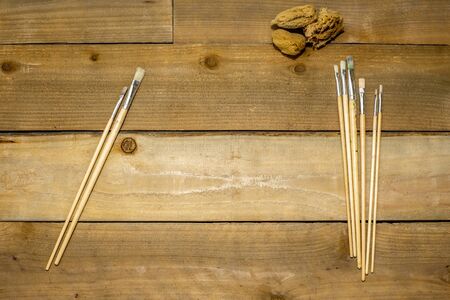 Paint brushes and sponges on a rustic distressed wooden backgroundの写真素材