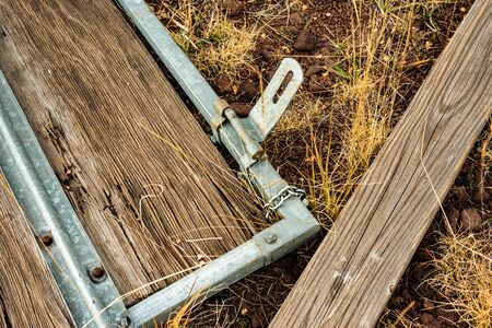 Broken wood gate with metal latch laying on the groundの写真素材