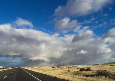 New Mexico highway with dramatic clouds in the sky ahead and open countryの写真素材