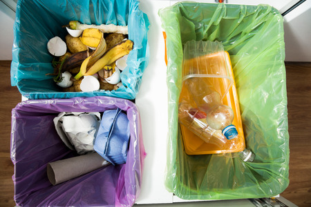 Garbage cans flat top view. Three trash bins with sorted garbage in kitchen cabinet with segregated household garbage - plastic, cardboard and bio cans shot from above. Ecology and recycle concept.の写真素材