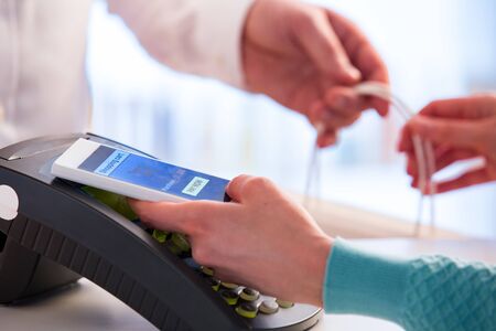 Wireless payment using smartphone and NFC technology. Close up. Customer paying with smart phone in...