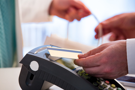 Customer paying with contactless card. NFC technology payment in store. Close Up. Shopping in pharmacy.の写真素材