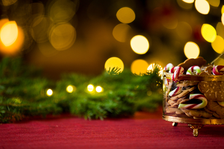 Close-up gingerbread and candy cane jar. Happy family holiday. Living room decorated with lights and candles and Christmas tree. Holiday moodの写真素材
