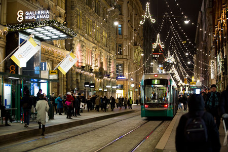 HELSINKI, FINLAND - DEC 17, 2017: Bright trams on central streets in Helsinki during Christmas. A lot of people, holiday sales and bright decorations.  City decorated with Christmas lightsのeditorial素材