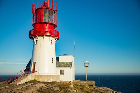 Old Lighthouse Lindesnes fyr is a coastal lighthouse located on the southernmost point of continental Norway in Lindesnes, South Cape. Serene Scandinavian landscape, Rocky Mountains, fjord, sunset skyの写真素材