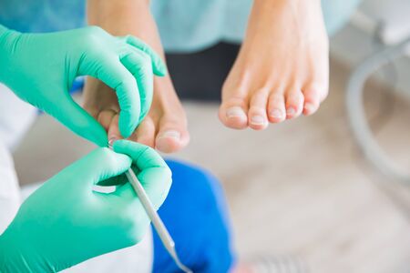 Woman sitting in chair, having foot treatment in spa salon.の写真素材