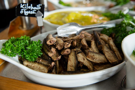 Smoked oil baltic sprats in a serving plate on a buffet table in a restorant. Seafood buffet lunch in a cafeの写真素材