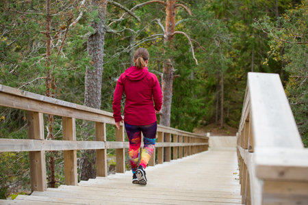 A sporty middle-aged woman training on a Fitness Stairs in a nature park in the forestの写真素材