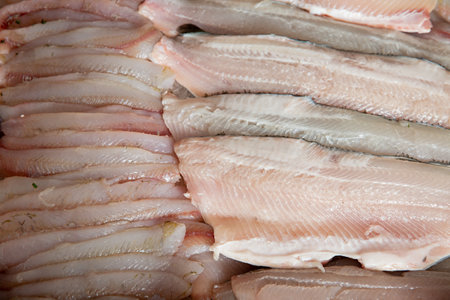 Fresh fish and seafood counter on market. White fish fillet close-up on displayの写真素材