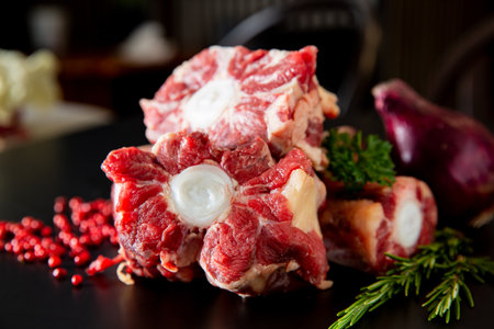 Fresh beef oxtails neatly arranged on a kitchen counter with herbs and spices. Flat lay showing raw meat ready for hearty recipes.の写真素材