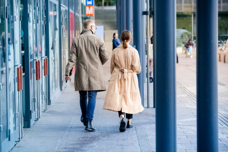 Business man and woman walking in city street, smiling and talking. Modern urban teamwork concept.の写真素材