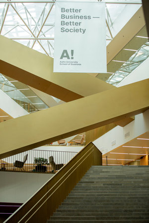 ESPOO, FINLAND - AUGUST 19, 2026: The modern interior of the Aalto University School of Business features intersecting staircases beneath a skylight.