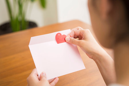 putting heart shape into an envelope