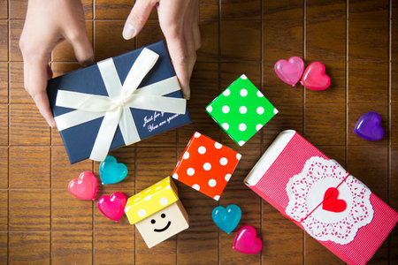 Multi-colored gift boxes on a wooden tableの写真素材